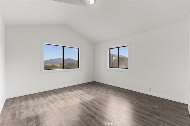 empty room with a mountain view, wood-type flooring, and lofted ceiling