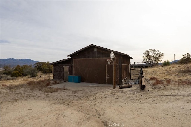 view of home's exterior with a mountain view and an outdoor structure