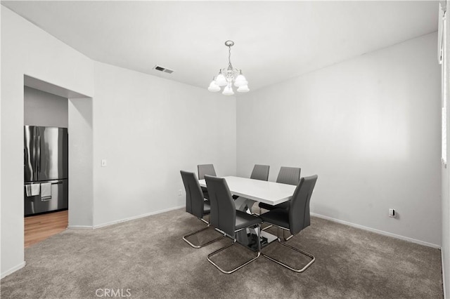 dining room featuring carpet and a notable chandelier