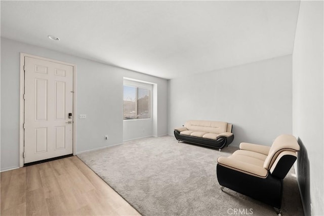 living area featuring carpet floors, wood finished floors, and baseboards