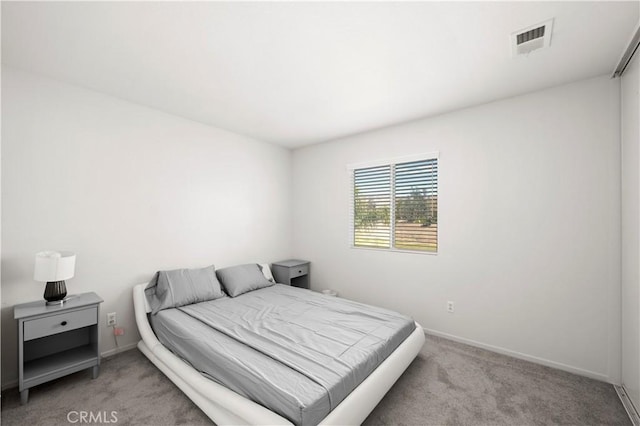 bedroom featuring baseboards, visible vents, and light colored carpet