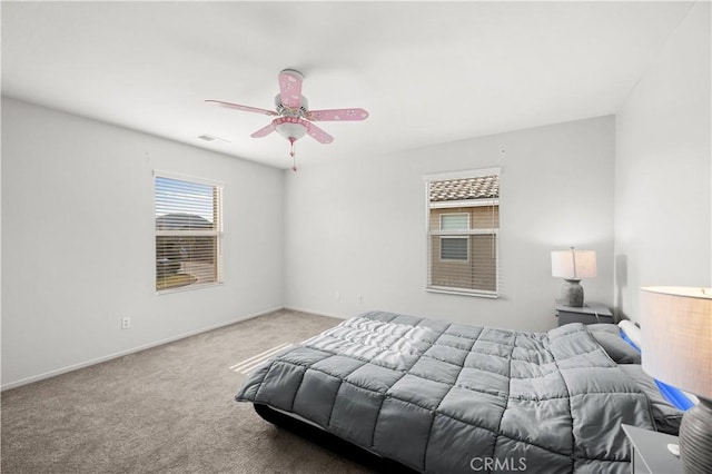 carpeted bedroom featuring baseboards, visible vents, and ceiling fan