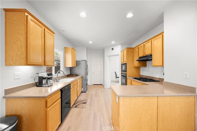 kitchen with black appliances, sink, light brown cabinetry, light hardwood / wood-style floors, and kitchen peninsula