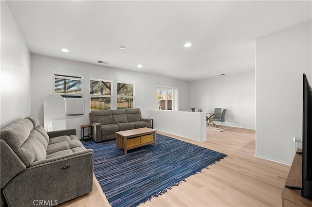 living room with baseboards, visible vents, wood finished floors, and recessed lighting