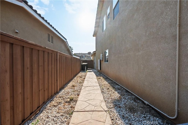 view of home's exterior with a tile roof, fence, and stucco siding