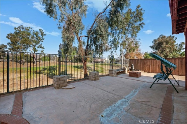 view of patio / terrace with an outdoor fire pit and fence