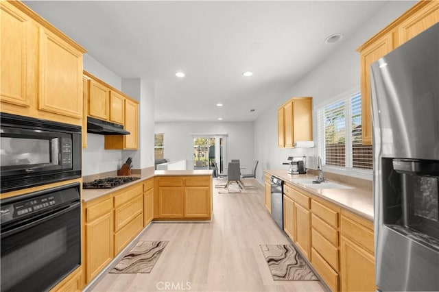 kitchen with light brown cabinets, black appliances, sink, light hardwood / wood-style flooring, and kitchen peninsula