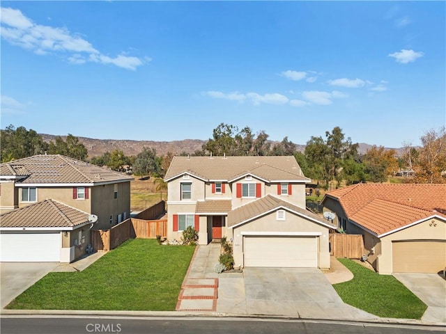 traditional home featuring driveway, a front lawn, an attached garage, and fence