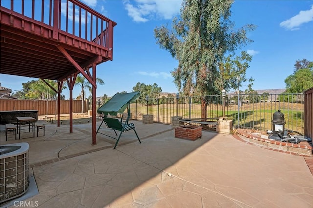 view of patio with central AC unit, an outdoor fire pit, and a fenced backyard