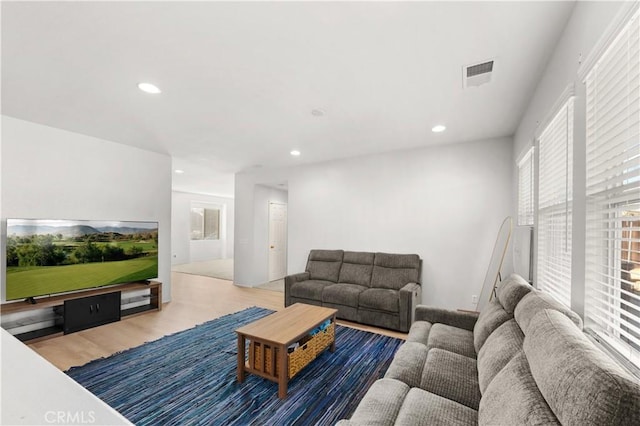 living area featuring recessed lighting, visible vents, and wood finished floors