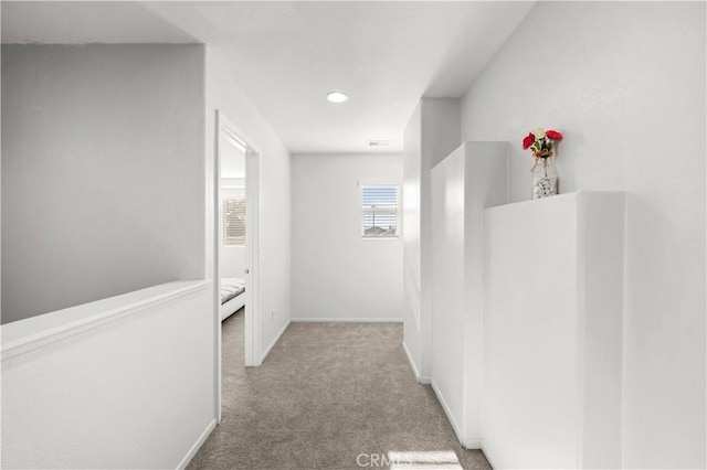 hallway featuring carpet, visible vents, and baseboards