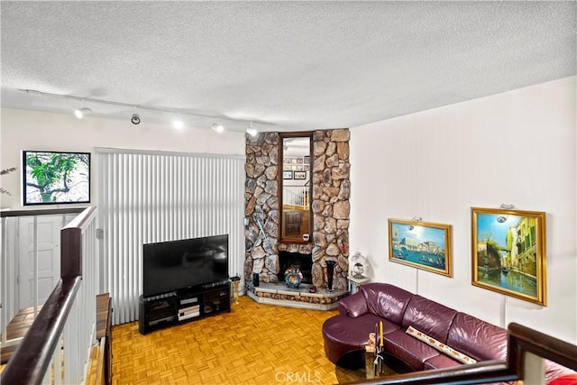 living room with a fireplace, a textured ceiling, and light parquet floors