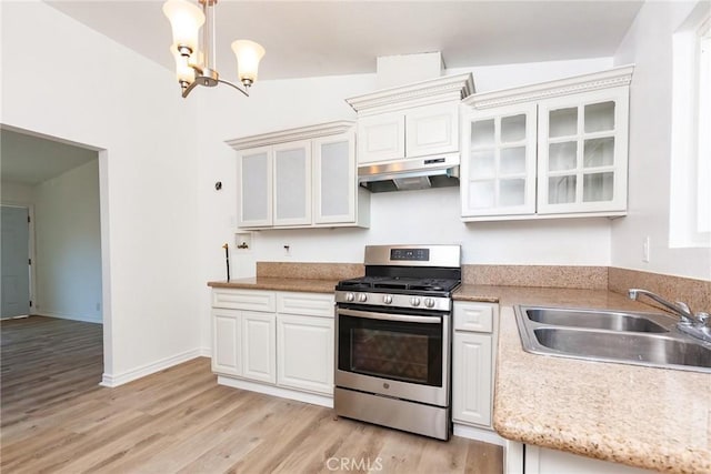 kitchen with stainless steel range, vaulted ceiling, sink, a notable chandelier, and white cabinetry