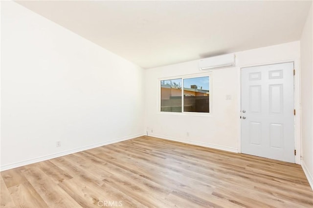 spare room with light hardwood / wood-style floors and a wall mounted AC