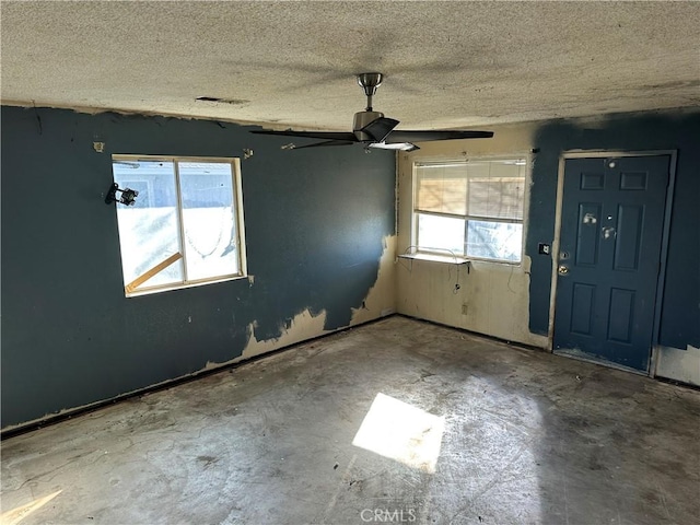 entrance foyer with ceiling fan, a healthy amount of sunlight, and a textured ceiling