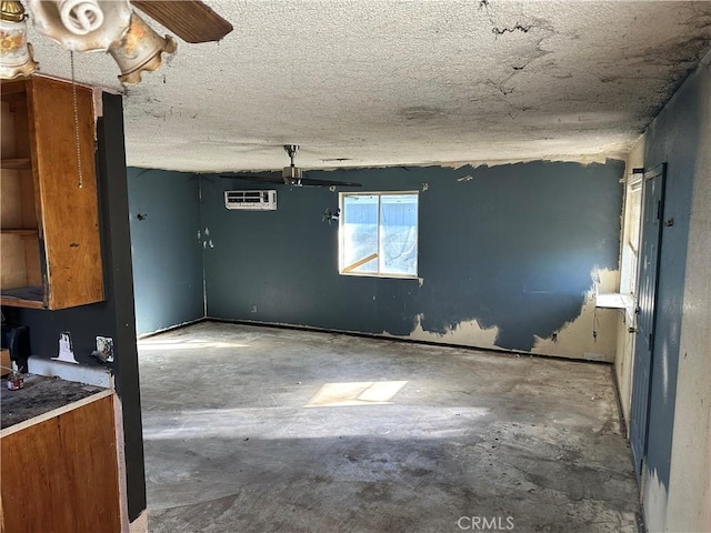 interior space with a wall mounted air conditioner and a textured ceiling