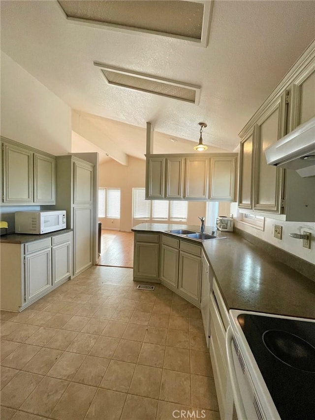 kitchen with sink, a textured ceiling, lofted ceiling, white appliances, and light tile patterned flooring