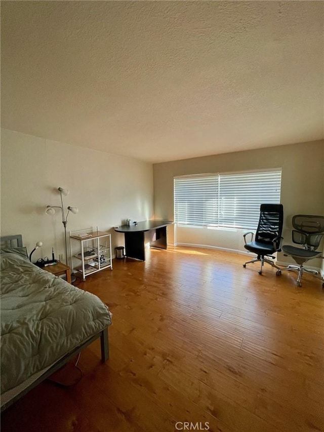 bedroom featuring wood-type flooring and a textured ceiling