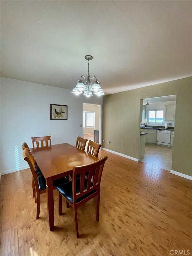 dining room with a chandelier, light hardwood / wood-style flooring, and a wealth of natural light