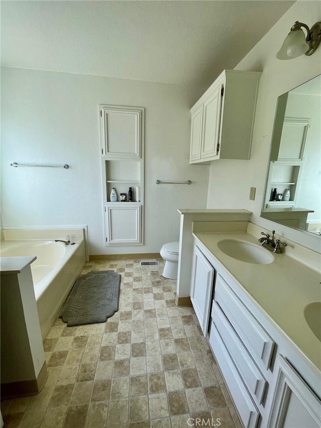 bathroom with a bathtub, toilet, a textured ceiling, and vanity