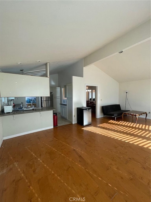 unfurnished living room with dark hardwood / wood-style flooring and lofted ceiling with beams