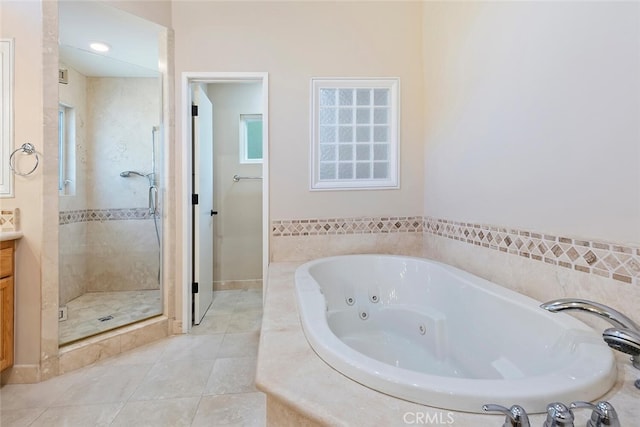 bathroom with tile patterned flooring, vanity, and shower with separate bathtub