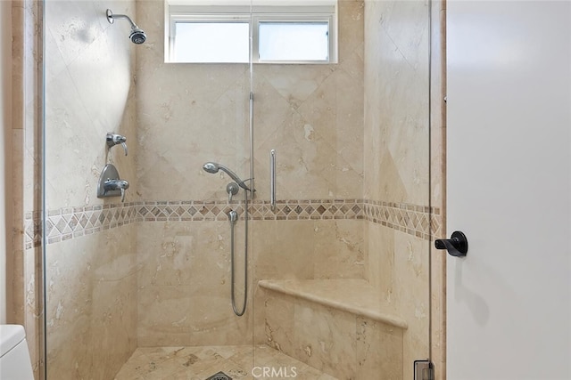 bathroom featuring a tile shower and toilet