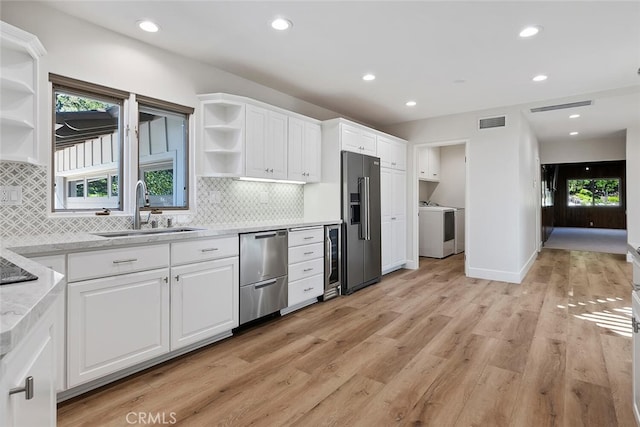 kitchen featuring sink, white cabinets, stainless steel appliances, and light wood-type flooring