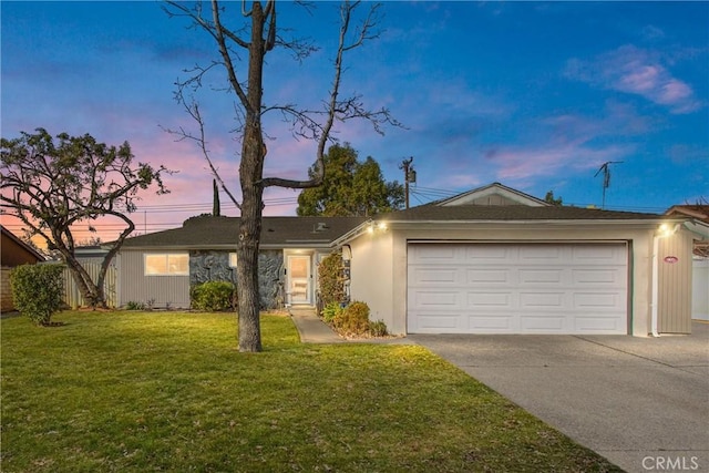 ranch-style home featuring a garage and a yard