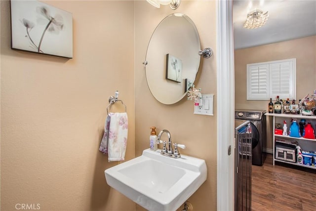 bathroom featuring washer and clothes dryer, wood-type flooring, and sink