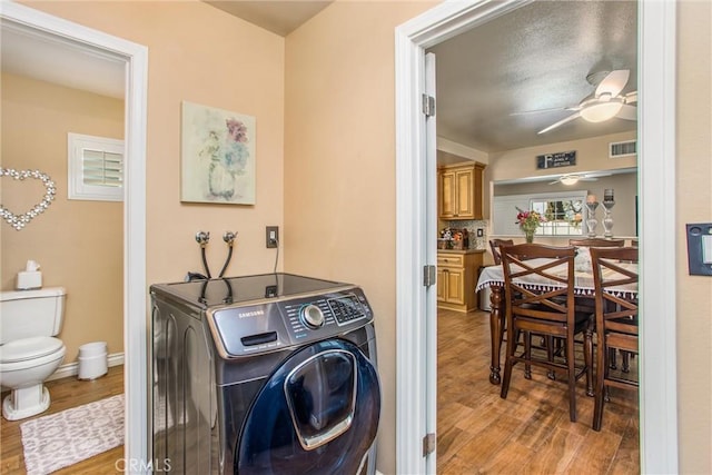 laundry area with ceiling fan, washer / dryer, and light hardwood / wood-style floors