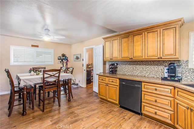 kitchen featuring ceiling fan, black dishwasher, decorative backsplash, light hardwood / wood-style flooring, and washer / clothes dryer