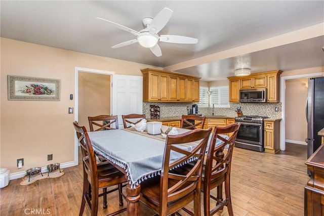 dining room featuring ceiling fan, light hardwood / wood-style floors, and sink