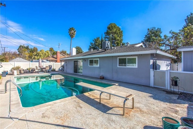 view of swimming pool with a patio area and a diving board