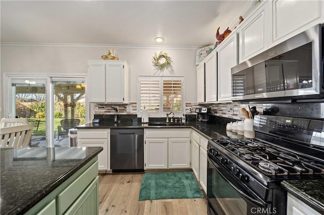 kitchen featuring dark stone countertops, white cabinetry, sink, and appliances with stainless steel finishes