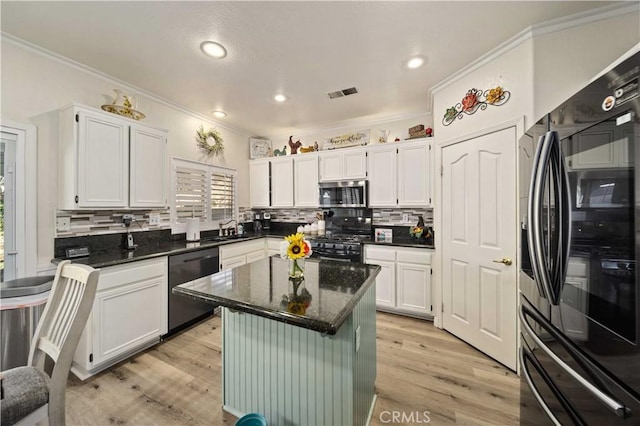 kitchen with black appliances, a center island, white cabinetry, and sink