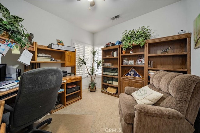 carpeted office space featuring ceiling fan