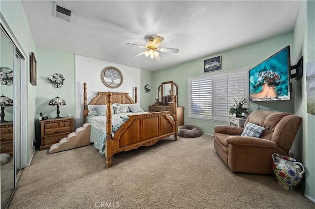 carpeted bedroom with ceiling fan and a closet