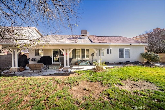 back of house with a yard and a patio