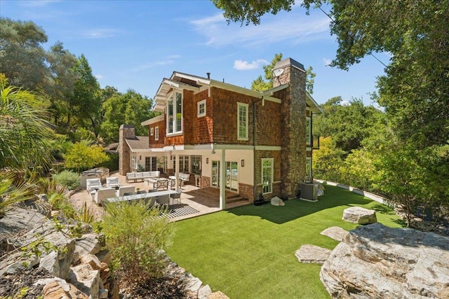 back of property with central AC unit, an outdoor living space, a patio area, and a yard