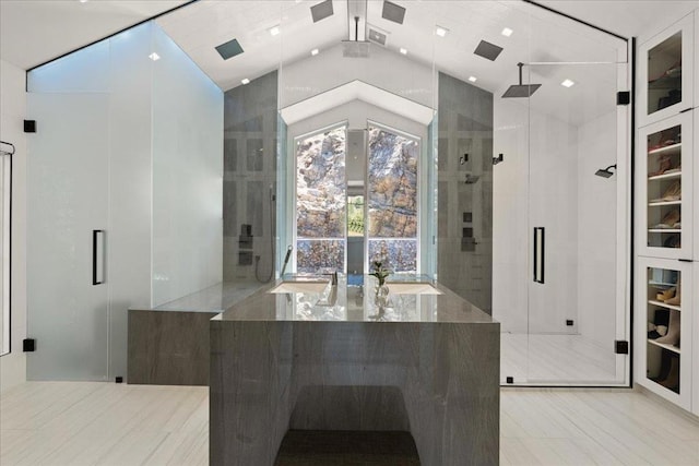 bathroom featuring a shower with shower door and vaulted ceiling