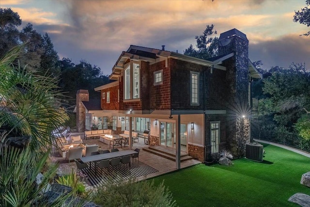 back house at dusk with central AC, a lawn, outdoor lounge area, and french doors