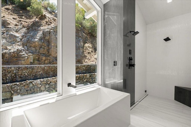 bathroom featuring independent shower and bath and tile walls