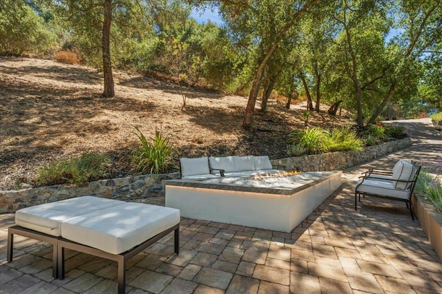 view of patio with an outdoor living space with a fire pit