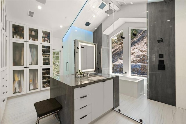 bathroom featuring walk in shower, vanity, and high vaulted ceiling