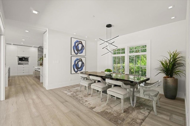 dining space with a notable chandelier and light wood-type flooring