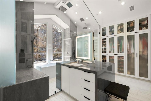 interior space featuring white cabinetry, sink, and vaulted ceiling