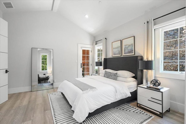 bedroom featuring high vaulted ceiling and light hardwood / wood-style flooring