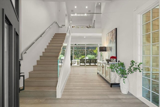 staircase featuring hardwood / wood-style flooring and a high ceiling