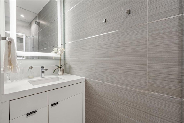 bathroom featuring vanity and tile walls